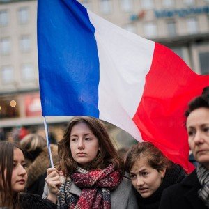 A young woman shows solidarity by holding aloft a French flag in the wake of the Paris terrorist attacks that has claimed 130 lives