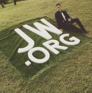 A Witness youth in Venezuela busily attends to not worshipping the JW.org logo